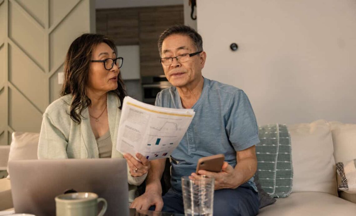 senior couple looks at investing statements
